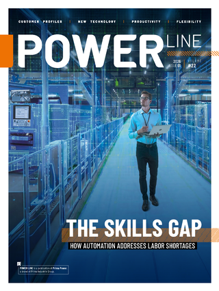 Magazine cover showing a man with a laptop in an automated factory setting.