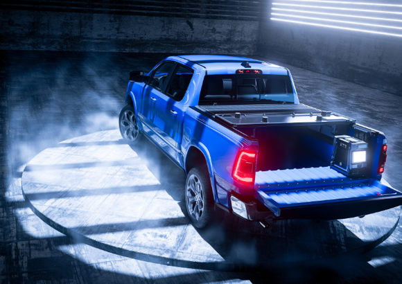 Blue pickup truck with tailgate down in a dimly lit, smoky garage