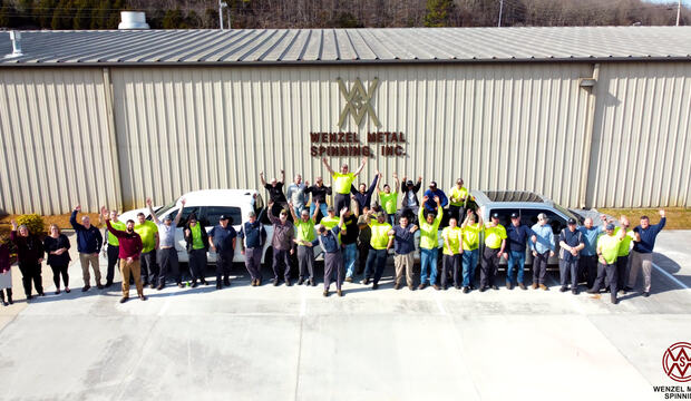 Large group of people waving in front of Wenzel Metal Spinning building.
