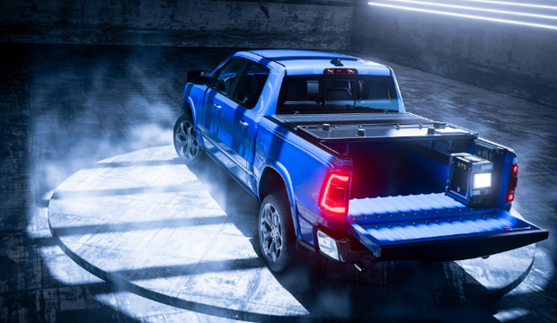 Blue pickup truck with tailgate down in a dimly lit, smoky garage